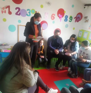 Grupo de adultos y un niño en taller educativo para padres.